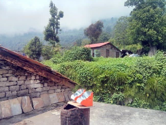 two orange coloured solar cookers kept atop the terrace of a village home stay in Sarmoli, Munsiyari, Uttarakhand, India