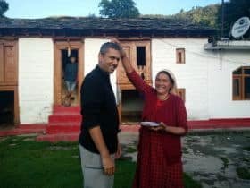 Home Stay host lady blessing the Author's husband before they parted in front of a Kumaoni village house
