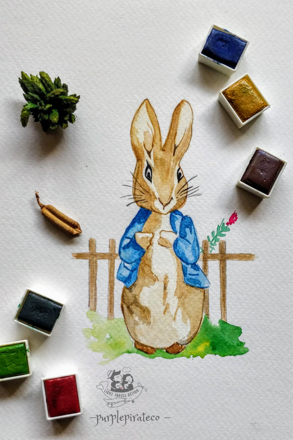 Peter Rabbit dressed in a proper blue blazer. Behind him is a small picket fence.