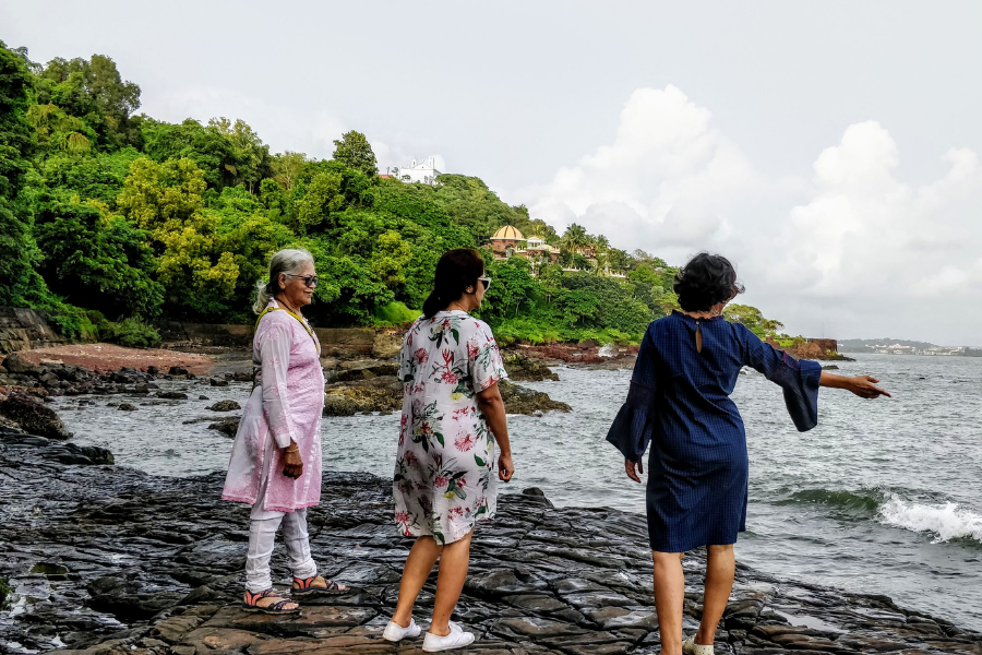 Tourist taking photos at the famous Aguada Central Jail steps overlooking the sea, demonstrating the photogenic appeal of this historic location