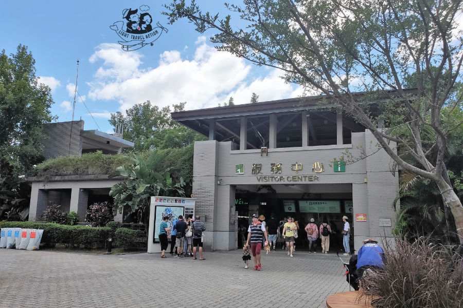 Taipei Zoo Visitor Center interior showing information desk with staff members wheelchair rental area and stroller services available for guests with signage
